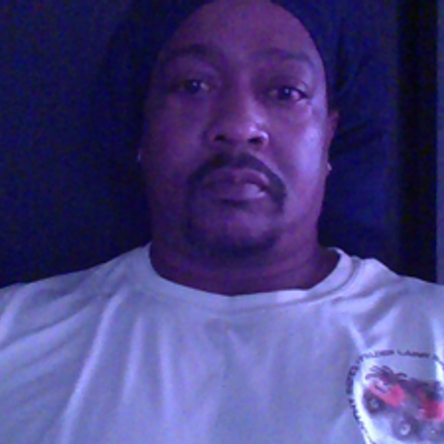 Smiling man with short hair and beard in a blue polo shirt