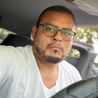 Smiling professional landscaping vendor with a beard wearing a GreenPal shirt