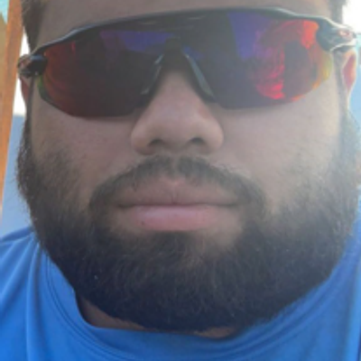 Professional GreenPal landscaper smiling in a dark blue polo shirt