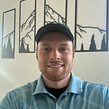 Smiling male lawn care professional with beard and sunglasses