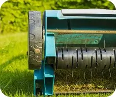 Spike aerator rollers on turf beside a lawn prepared for core aeration in Portland, ME