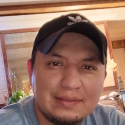 Smiling professional landscaper with short dark hair in a dark polo shirt