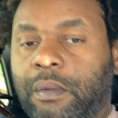 Smiling male landscaping professional in a grey collared shirt