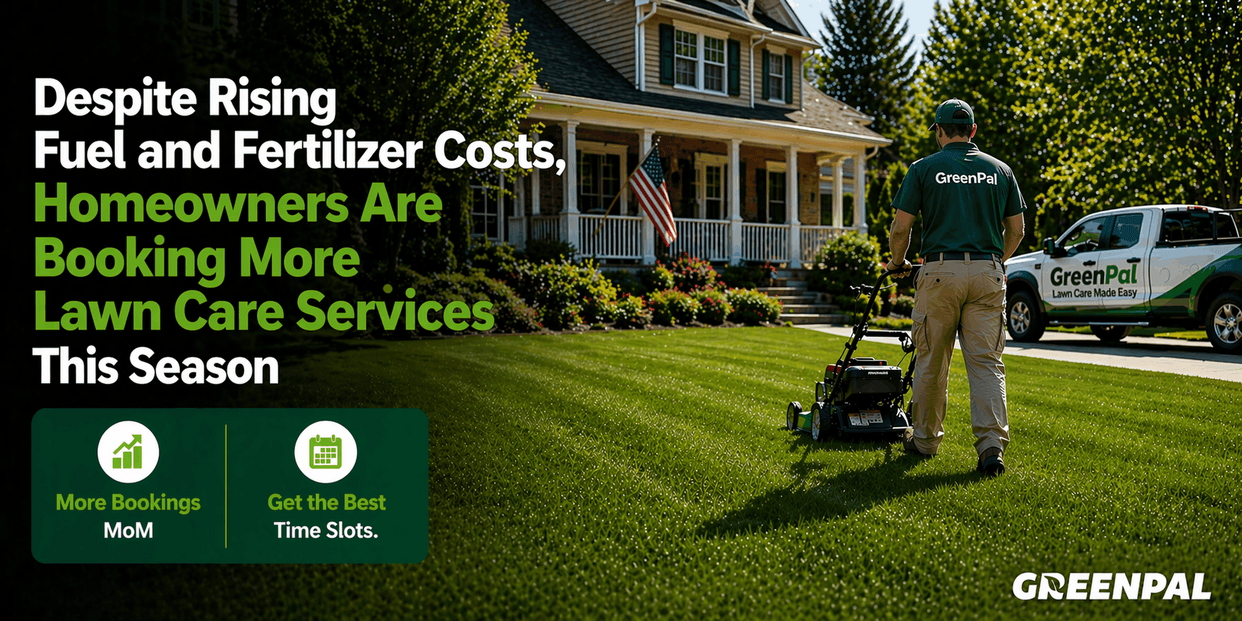 A lawn care professional mows a vibrant green lawn in front of a suburban home.